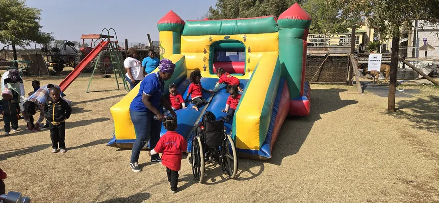 Learners climbing and sliding on a jumping castle