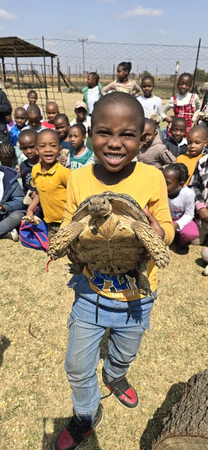 A learner holding a young goat